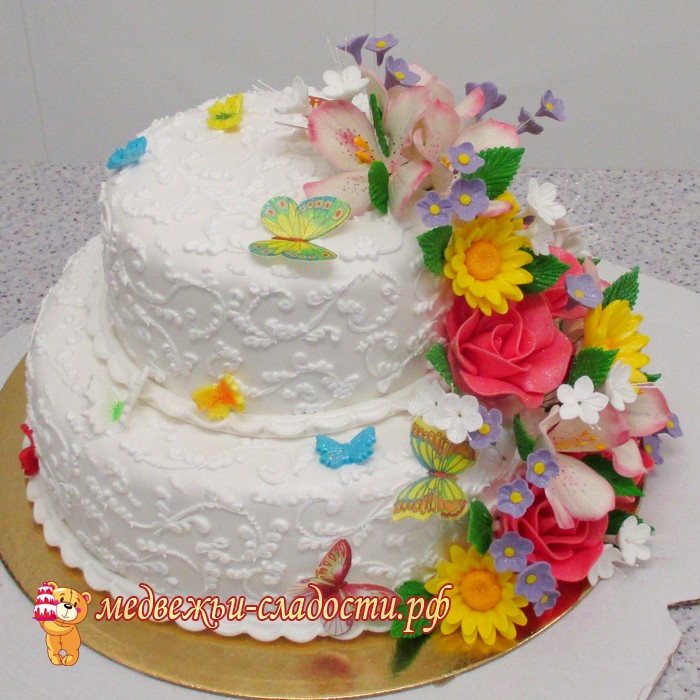 Свадебный торт с узорами в два яруса и гирляндой цветов